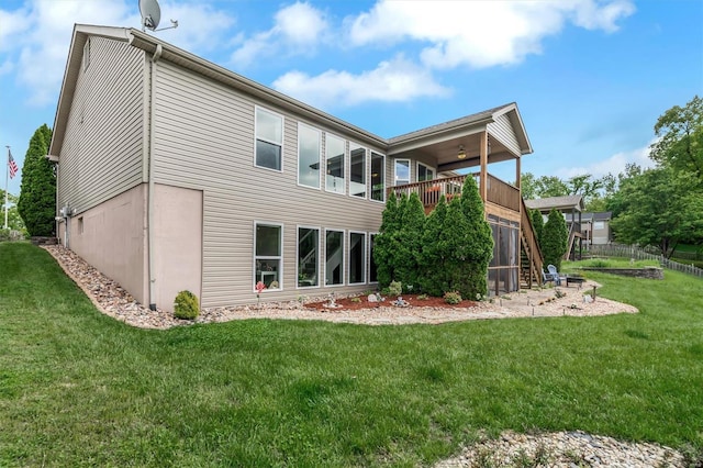 back of house featuring ceiling fan and a lawn