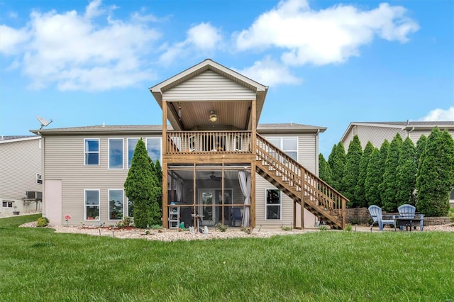 back of house with a ceiling fan, a sunroom, a balcony, a yard, and stairs
