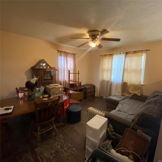 interior space featuring ceiling fan, a textured ceiling, a healthy amount of sunlight, and wood finished floors