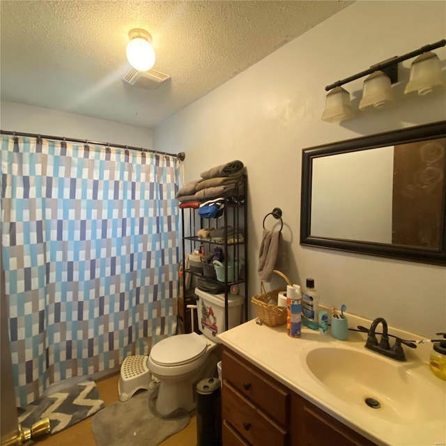 bathroom featuring toilet, vanity, curtained shower, a textured ceiling, and visible vents