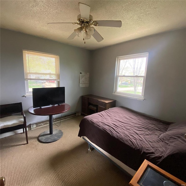 carpeted bedroom with ceiling fan, a textured ceiling, and multiple windows