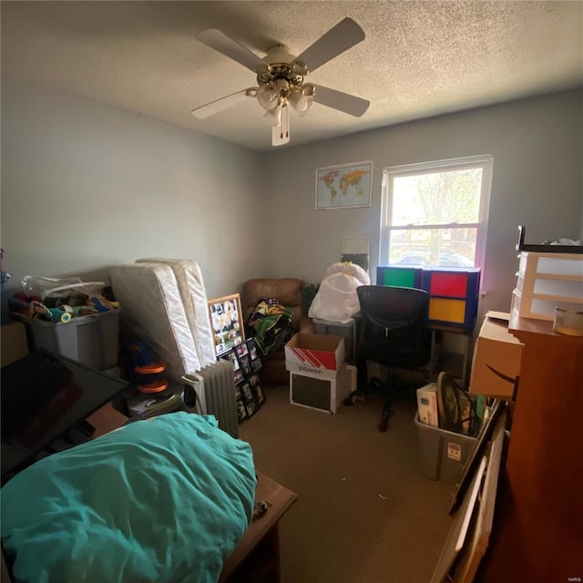 carpeted bedroom with ceiling fan and a textured ceiling
