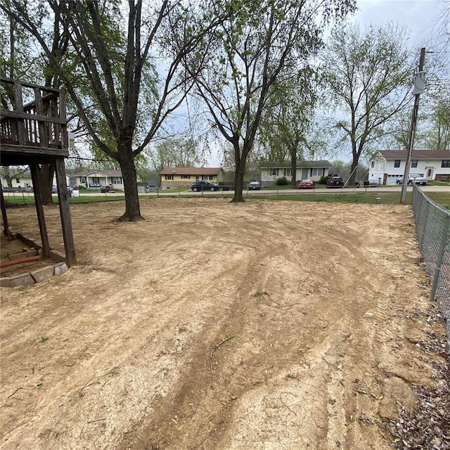 view of yard featuring fence, a wooden deck, and a residential view