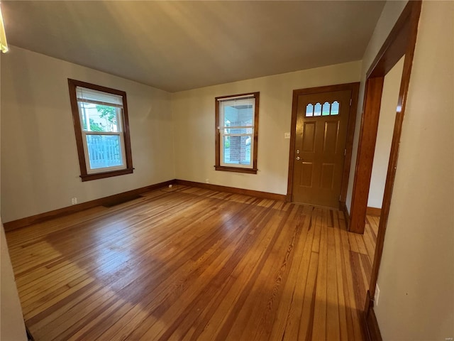 foyer entrance featuring baseboards and light wood finished floors