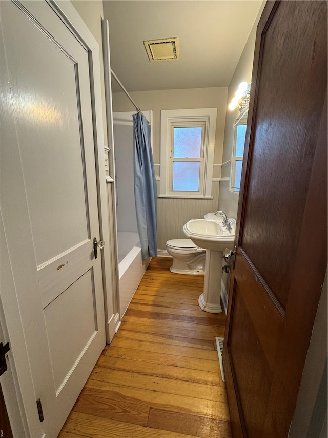 full bathroom with toilet, visible vents, hardwood / wood-style floors, and a sink