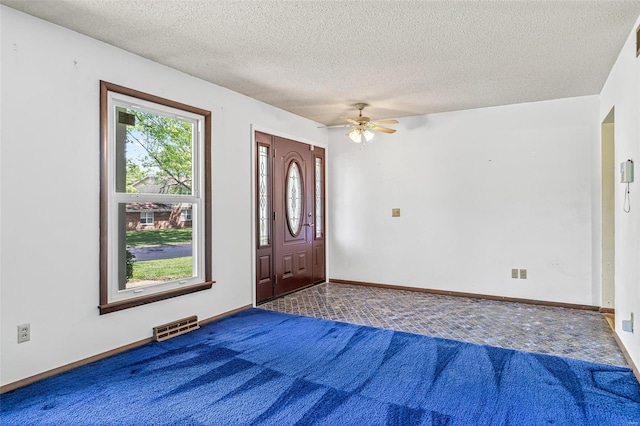 unfurnished bedroom featuring carpet flooring, a textured ceiling, a ceiling fan, and baseboards