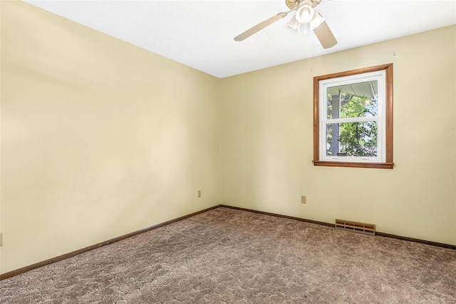 carpeted spare room with a ceiling fan and baseboards
