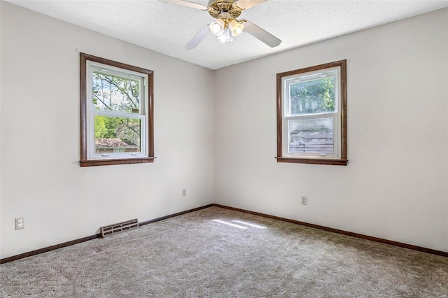 carpeted empty room featuring baseboards and a ceiling fan