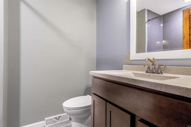 bathroom with toilet, vanity, and baseboards