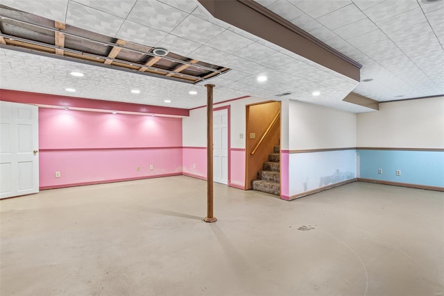 finished basement featuring baseboards, stairs, and recessed lighting