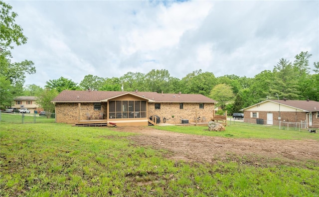 rear view of property featuring a sunroom and a deck