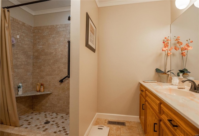 full bath with a tile shower, crown molding, vanity, tile patterned floors, and baseboards