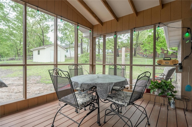 sunroom featuring outdoor dining space and lofted ceiling