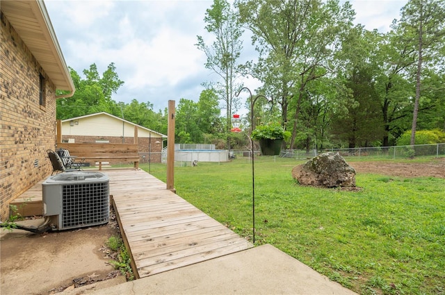 view of yard featuring central AC and view of scattered trees