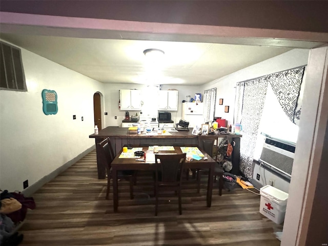 dining room with arched walkways and dark wood-type flooring