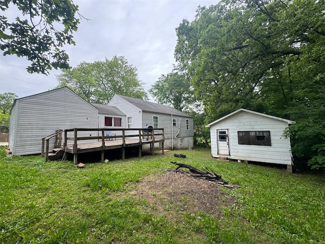 view of grassy yard with a deck, an outbuilding, and a storage unit
