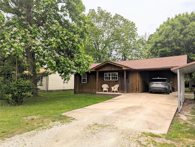 ranch-style home featuring concrete driveway, a front lawn, and a carport