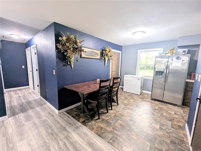 dining area with a textured ceiling and baseboards