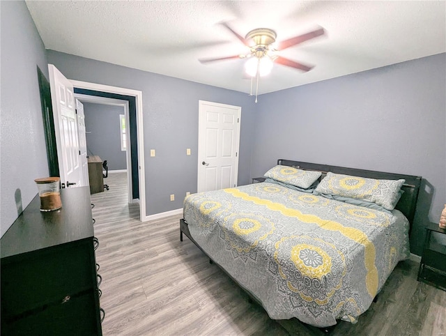 bedroom with wood finished floors, baseboards, and ceiling fan