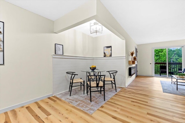 dining room featuring a chandelier, wood finished floors, and baseboards