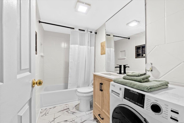 full bath with washer / clothes dryer, marble look tile flooring, shower / tub combo with curtain, vanity, and toilet