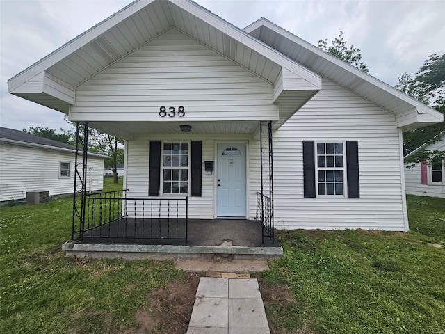view of front facade featuring a porch, a front yard, and central air condition unit