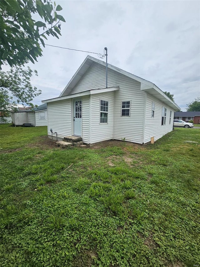 rear view of house featuring a yard