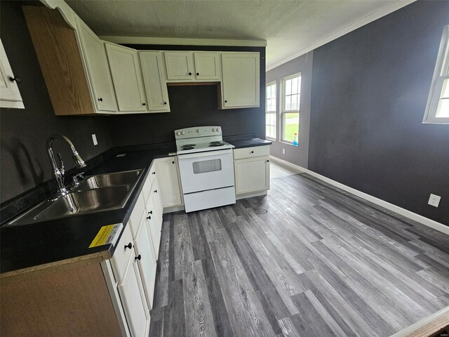 kitchen featuring white range with electric stovetop, a sink, dark wood-style flooring, dark countertops, and a textured ceiling