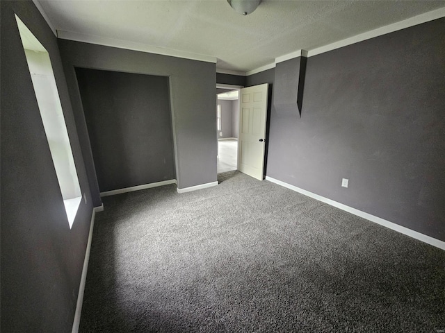 unfurnished bedroom featuring ornamental molding, carpet flooring, and baseboards