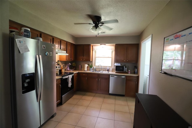 kitchen featuring stainless steel appliances, under cabinet range hood, a sink, a ceiling fan, and light countertops