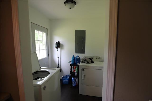 washroom with electric panel, washer and dryer, and wood finished floors