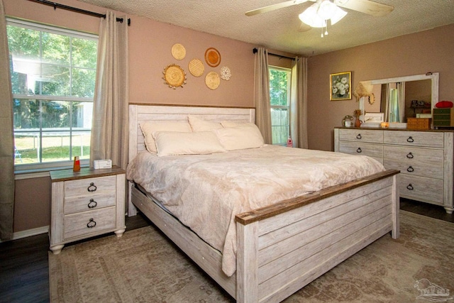 bedroom featuring multiple windows, a textured ceiling, and ceiling fan