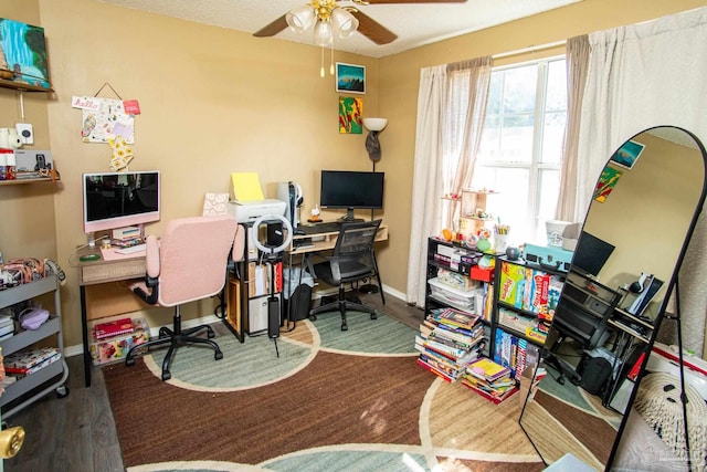 office area featuring a ceiling fan and baseboards