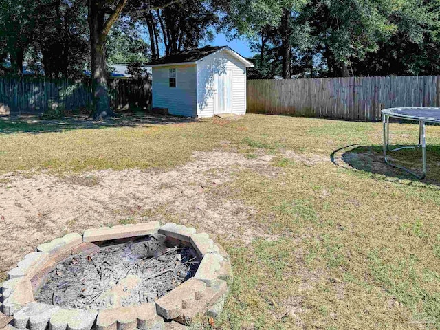 view of yard with an outdoor fire pit and a storage shed