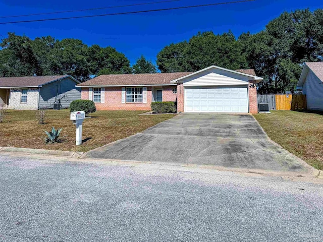 single story home with a front lawn, central AC unit, and a garage