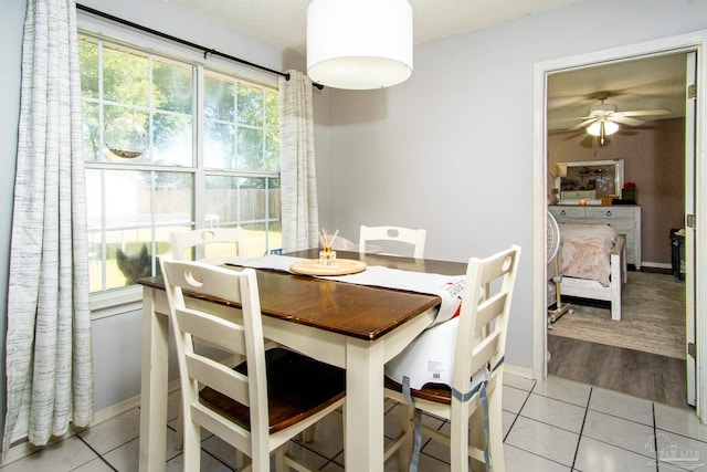 tiled dining room featuring a textured ceiling and ceiling fan