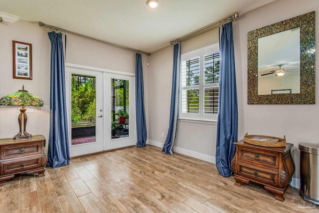 interior space with french doors, light wood-type flooring, and ceiling fan