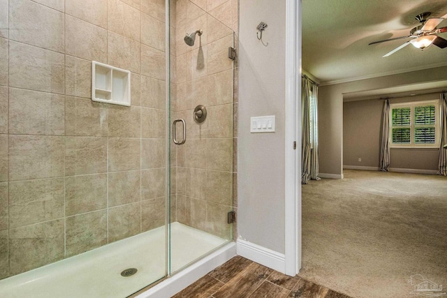 bathroom featuring a shower with door, ceiling fan, wood-type flooring, and ornamental molding