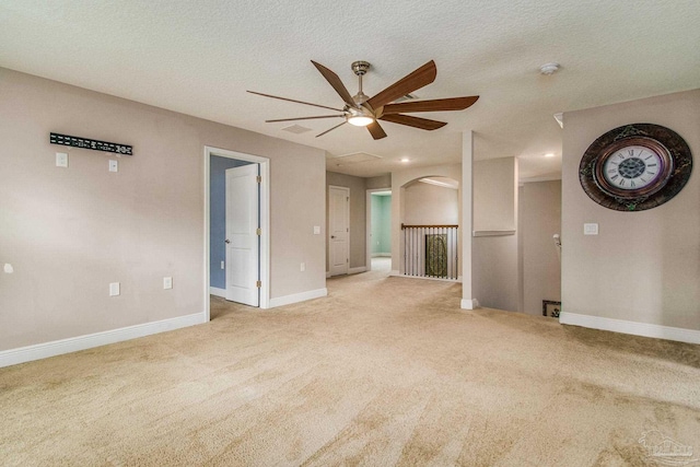 unfurnished living room with light carpet, a textured ceiling, and ceiling fan