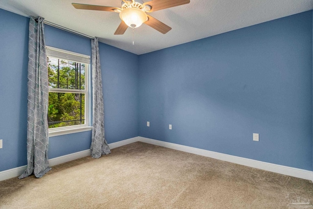 spare room featuring carpet, a healthy amount of sunlight, and ceiling fan