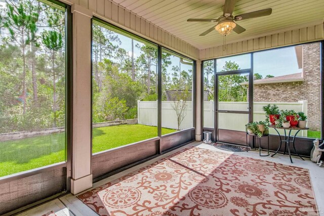 unfurnished sunroom with ceiling fan