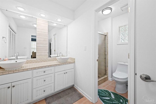 bathroom with tile patterned floors, toilet, vanity, and an enclosed shower