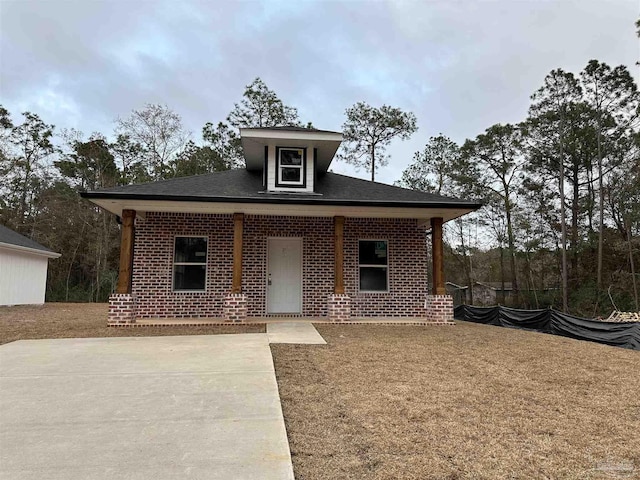 view of front facade featuring brick siding and covered porch