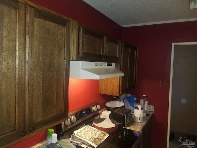 kitchen with ornamental molding, a textured ceiling, and wall chimney range hood