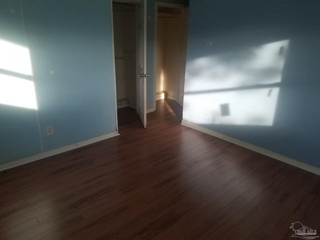 empty room with dark hardwood / wood-style flooring