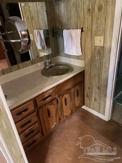 bathroom featuring vanity and wooden walls