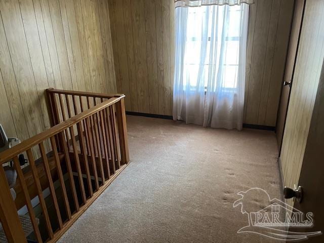 interior space featuring wooden walls and light colored carpet