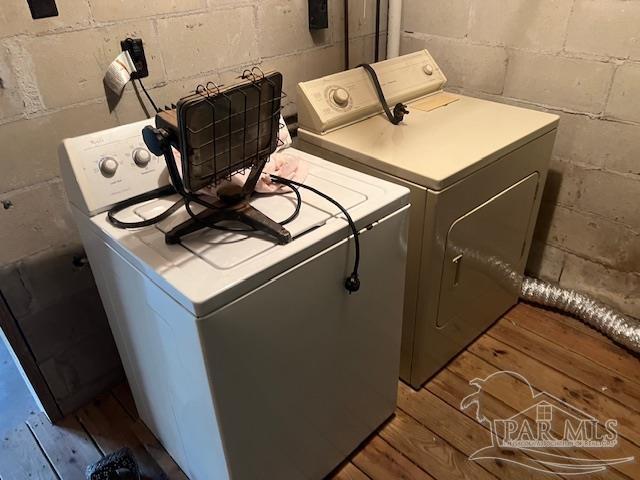 clothes washing area featuring washer and clothes dryer and light wood-type flooring