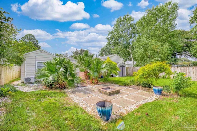 view of yard featuring ac unit, a storage shed, a patio area, and an outdoor fire pit