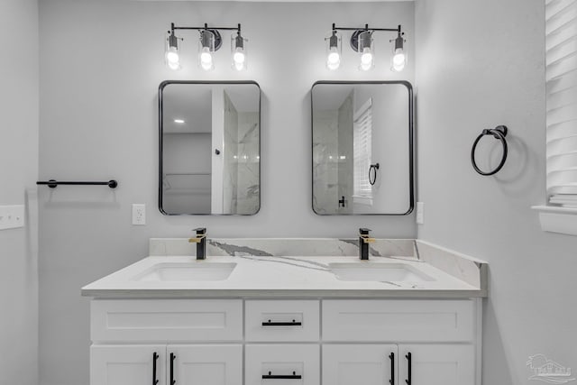 bathroom with double vanity, walk in shower, and a sink